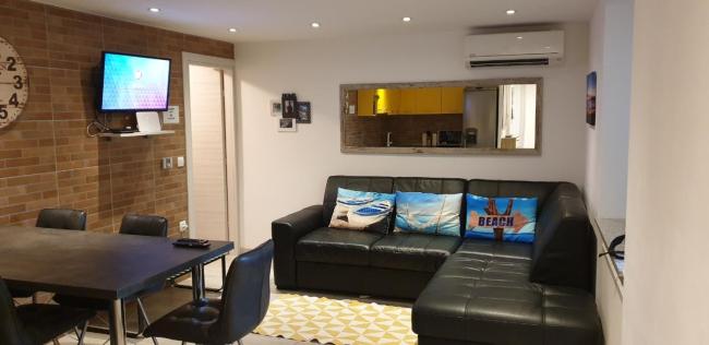Dnevni boravak Apartmana Sevilya s kutnom garniturom, televizorom i blagovaonicom